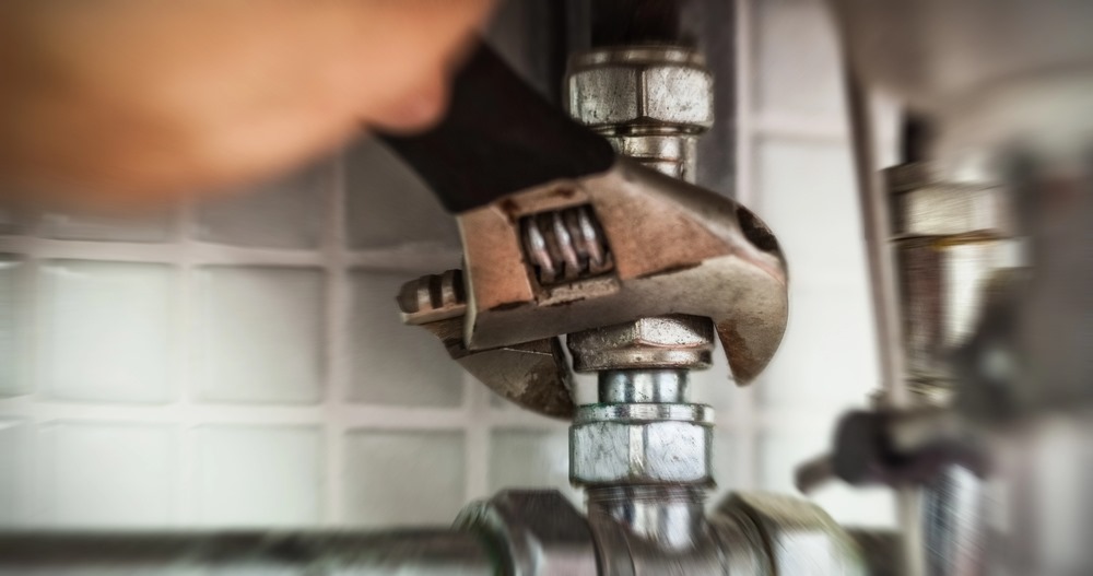 Image of a hand repairing pipes with a wrench, featuring Hero Service Pros and highlighting technology that's plumber-tested and pro-approved for reliable plumbing solutions.